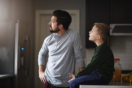 Ill teach you all about this world. a handsome young man and his son in the kitchen at home.の写真素材