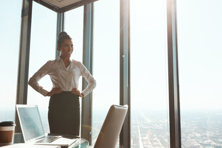 Shes made a success of herself. an attractive young businesswoman standing with her hands on her hips in the office.の写真素材