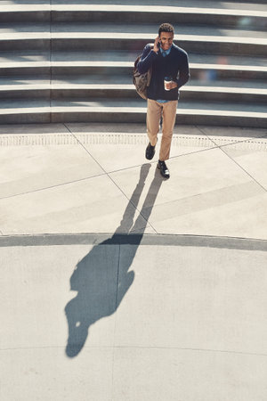 Get going, get it done. a young businessman using a mobile phone while walking through the city.