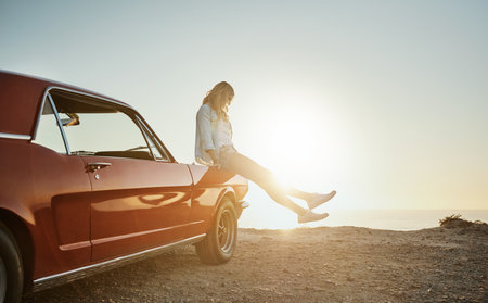 Life is either a daring adventure or nothing at all. a young woman enjoying a road trip along the coast.の写真素材