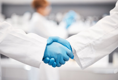 Doctor, shaking hands and gloves for safety in healthcare, partnership or trust for collaboration, unity or support at lab. Team of medical experts handshake in teamwork for agreement or successの写真素材