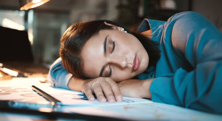Sleeping, tired and office business woman at night with planning paperwork for mental health or time management. Fatigue, burnout and corporate employee sleep on desk at a global networking companyの写真素材