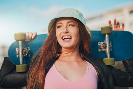Youth, freedom and skateboard with woman in city for summer, sports and relax lifestyle. Training, fitness and happy with girl walking in urban town enjoying adventure, wellness and skating breakの写真素材