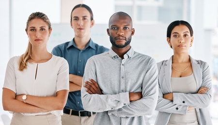 Motivation, arms crossed and serious with business people standing in corporate company building together. Innovation teamwork and goals with employees in conference, workshop or meetingの写真素材