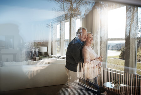 Keep looking to the bright side of life. a loving mature couple relaxing together at home.の写真素材