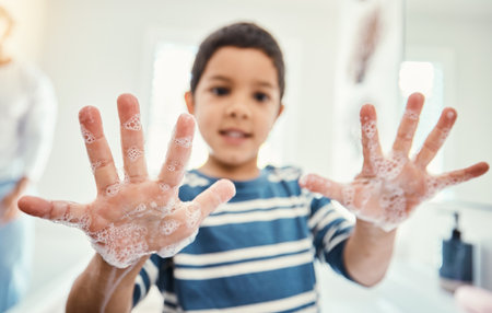Cleaning, hands with soap and boy in bathroom for hygiene, wellness and healthcare at home. Healthy family, skincare and portrait of child with open palms washing with water, soap and disinfectionの写真素材