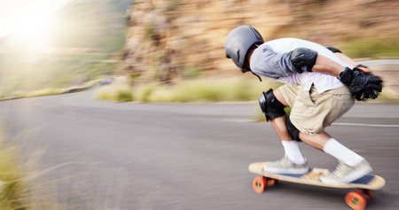 Skateboard, motion blur and man speed in road for sports competition, training and exercise in city. Skating, skateboarding and male skater for adrenaline, adventure and freedom in extreme challengeの写真素材