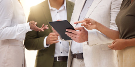 Hands, tablet and collaboration with a business team working on research together in their office. Teamwork, meeting or planning with a man and woman employee group discussing strategy at workの写真素材