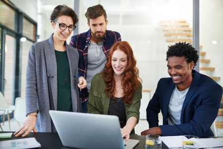 Theyre always exceeding expectations. a group of young creatives working together on a laptop in a...