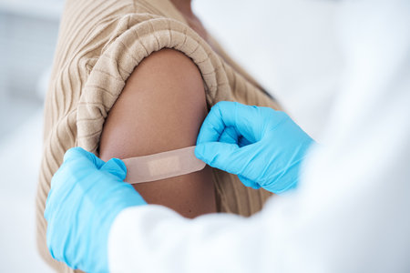 Doctor, vaccine and woman with plaster on arm for healthcare, wellness services and medicine. Immunity injection, bandage and medical healing in hospital, surgery and clinic consulting of vaccinationの写真素材