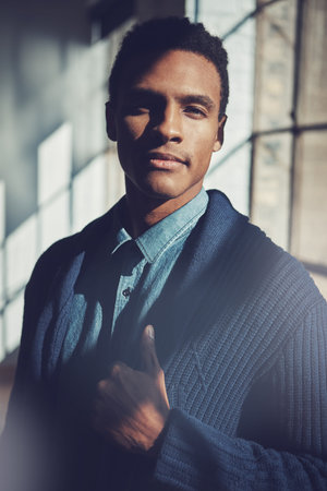 Nothing accomplishes goals like self belief. a handsome young businessman standing in a modern office.の写真素材