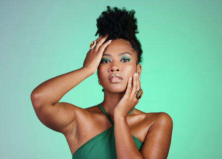Fashion model in studio, black woman on green background in Brazil and beauty makeup portrait on confident skin. Afro hair on modern african girl, elegant pose with ring jewelry and cosmetic lipstickの写真素材