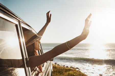 Now this is living. a young woman enjoying a road trip along the coast.の写真素材