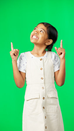 Face, pointing and girl with motivation, green screen and choice with inspiration, happiness and show. Portrait, female child and young person with direction, decision and promotion with joy or smileの写真素材
