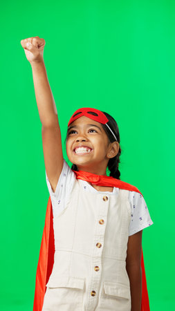 Costume, face and child in a studio with green screen doing a superhero pose and outfit. Happy, smile and portrait of a girl kid from Mexico in cosplay clothes by a chroma key background with mockup.の写真素材
