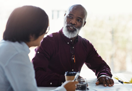 Turning his expertise into guidance. two businessmen having a discussion in an office.の写真素材