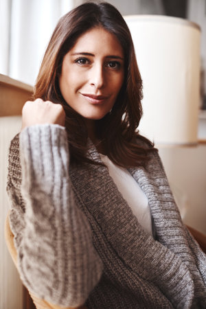 What am I doing this weekend Absolutely nothing. Portrait of an attractive young woman relaxing on a chair at home.の写真素材