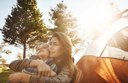 I love bonding with you in nature. a young beautiful mother and her son camping in the forest.の写真素材