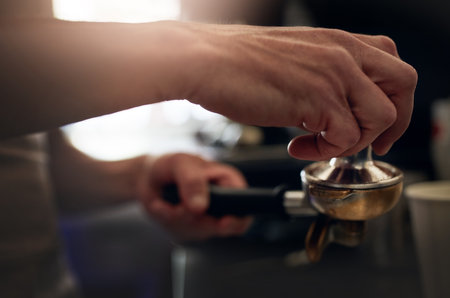 Preparing the perfect brew. Closeup shot of an unrecognizable barista operating a coffee machine in a cafe.の写真素材