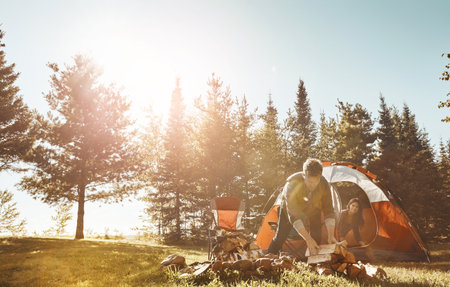 Making sure all the wood is in order. a young married couple camping in the forest.の写真素材
