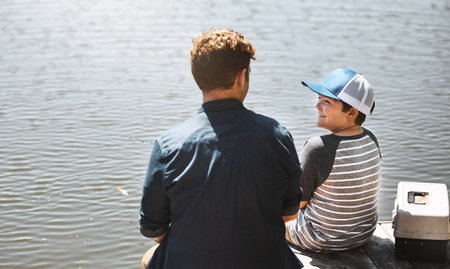 I wonder what our catch of the day will be. Rear view shot of a father and his little son fishing together.の写真素材