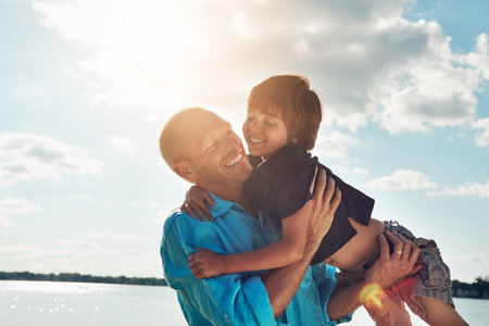 Make sure they know just how much you love them. a middle-aged man and his young son spending some quality time at the beach.の写真素材