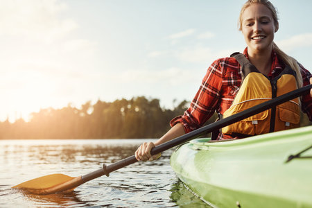 Im enjoying every minute of this. an attractive young woman out for canoe ride on the lake.