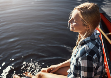 No better place to chill. High angle shot of an attractive young woman spending a day relaxing by the lake.の写真素材
