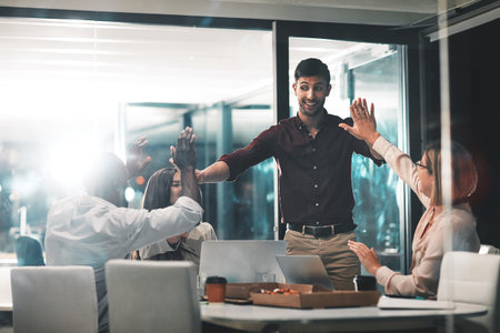 Winning is what happens when you work with the best. colleagues giving each other a high five during...