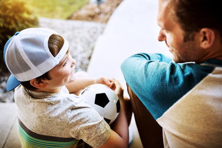 Give them the one-on-one attention they deserve. Rearview shot of a father and his son bonding on their porch at home.の写真素材