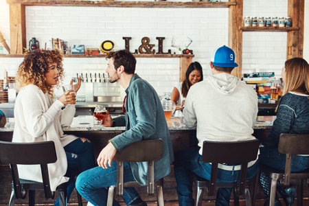 Do you prefer this or that drink. young people enjoying a drink at a bar.の写真素材