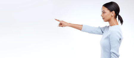 Mock up woman, studio profile and pointing at sales promotion, advertising space or discount deal mockup. Commercial branding, marketing gesture or product placement female on white background bannerの写真素材