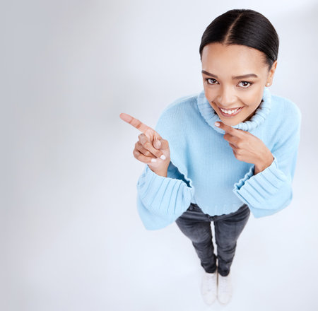Happy mockup portrait, woman face and pointing at sales promotion, advertising copy space or discount deal mock up. Brand commercial, studio top view or product placement female on white backgroundの写真素材