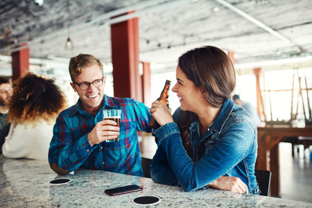 Laughing with you makes my day. a couple enjoying a drink at a bar.の写真素材