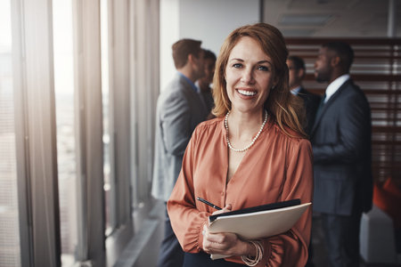 Busy making big plans for the future. Portrait of a professional businesswoman standing in an office with colleagues in the background.の写真素材