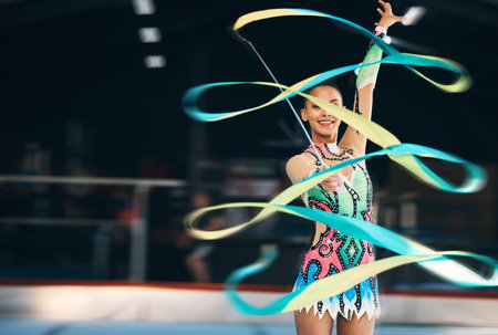 Ribbon dancing, portrait and happy woman in gymnastics competition, talent show and dark mockup arena. Female dancer, rhythmic movement and smile for action, creative performance and sports concertの写真素材