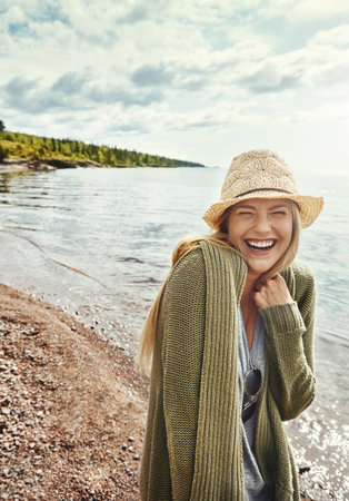 Smiles all round on a sunny day. a young woman spending a day at the lake.の写真素材