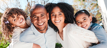 Family, children and portrait outdoor with parents in nature with love and care. Happy kids, man and woman together for support, piggyback or quality time with hug and smile for happiness or securityの写真素材