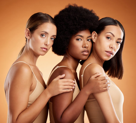 Diversity, women and natural beauty skincare and wellness cosmetics. Proud, confident and healthy girls portrait together, morning facial and body care routine in studio with brown background.の写真素材