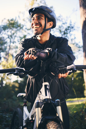 Forest, fitness and smile, cyclist on bicycle in nature with helmet, exercise adventure trail and...