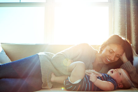One on one time with her little one. a young woman bonding with her baby boy on the sofa at home.の写真素材