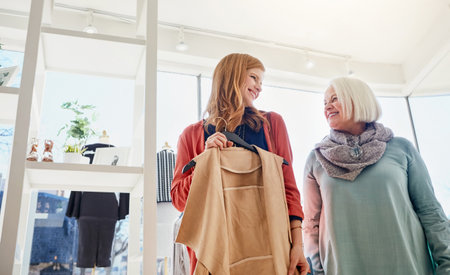 We just cant resist a bargain. a mother and daughter shopping in a clothing boutique.の写真素材