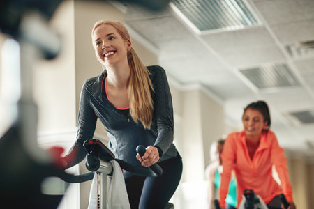 Just keep spinning. a young woman working out with an exercise bike in a spinning class at the gym.