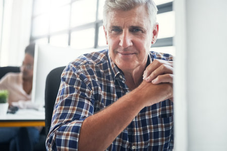 Work like youre going to retire tomorrow. Portrait of a male designer sitting at his desk.の写真素材