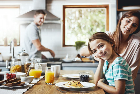 Enjoying the most important meal of the day together. a little girl having breakfast with her parents at home.の写真素材