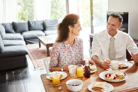 Breakfast tastes ten times tastier when shared with your dearest. a mature couple having breakfast together at home.の写真素材