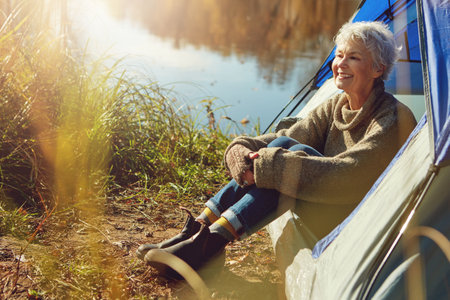 Theres so much to appreciate here in the great outdoors. a senior woman camping in the wilderness.の写真素材