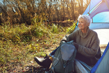 Keep calm and camp on. a senior woman camping in the wilderness.の写真素材