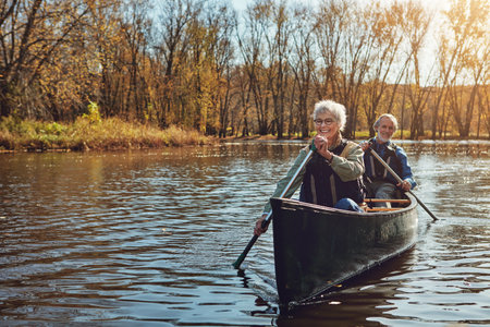 Hes her hubby and canoeing buddy. a senior couple going for a canoe ride on the lake.の写真素材