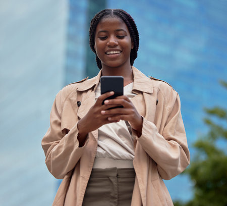 Phone, business and black woman typing in city, internet browsing or social media. Technology, cellphone or female employee with 5g mobile smartphone for research, networking or web scrolling in townの写真素材